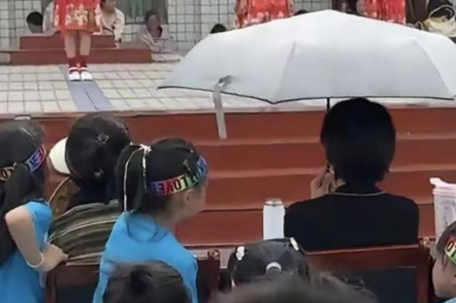 六一演出观众席C位老师独自打伞