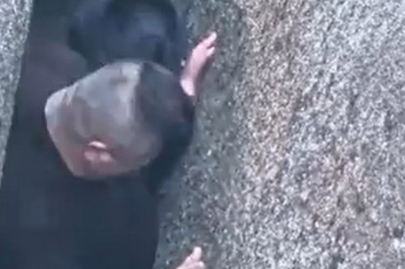 男子过“一线天”被卡 肚子磨破皮