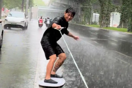 成都男子在暴雨中街头冲浪