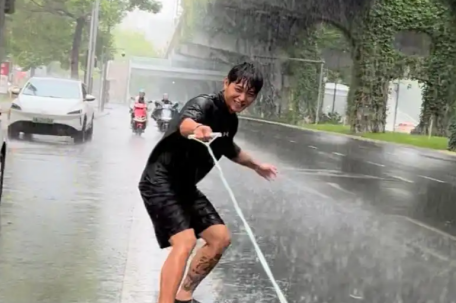 成都一男子在暴雨中的街头滑板冲浪