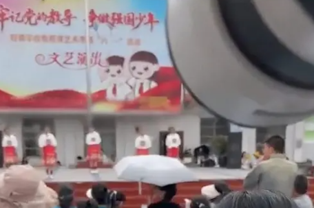 孩子淋雨演出老师打伞观看？假
